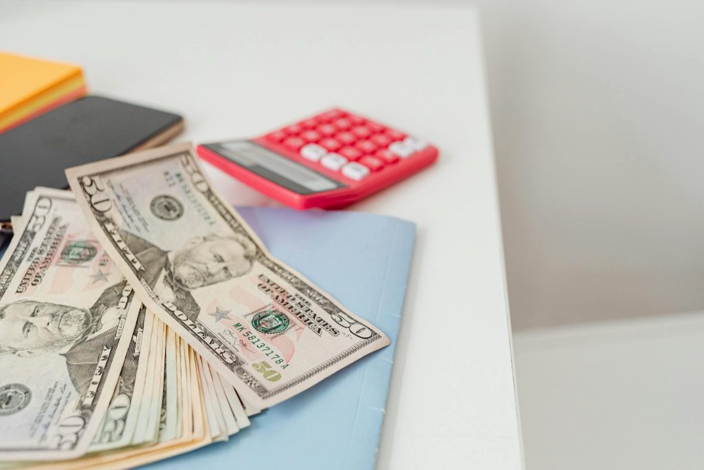 Notebooks and US dollars for saving money in a high yield savings account