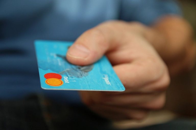 Hand holding a credit card, representing how your credit score affects borrowing