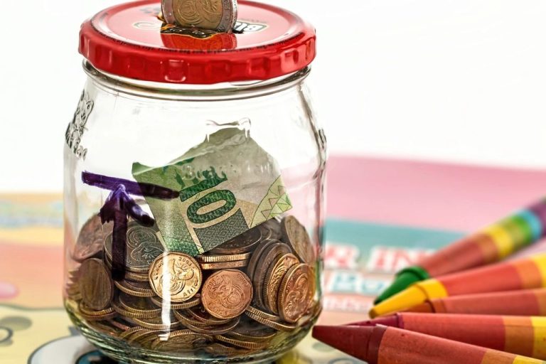 Glass savings jar filled with cash and coins for an emergency fund