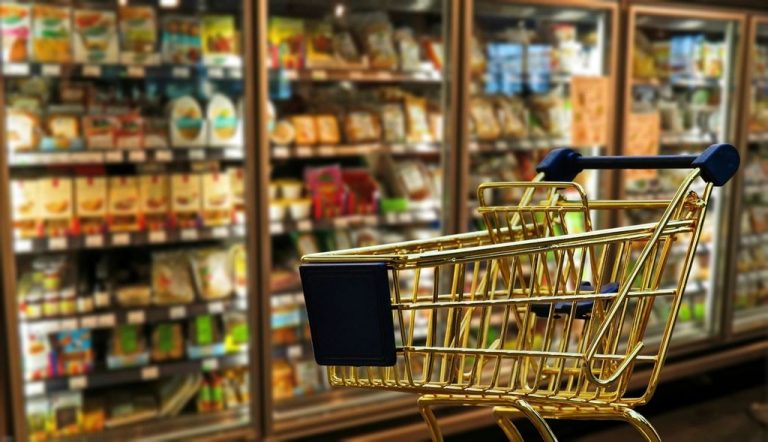 Shopping cart in a grocery store aisle, showing how to beat inflation as prices rise