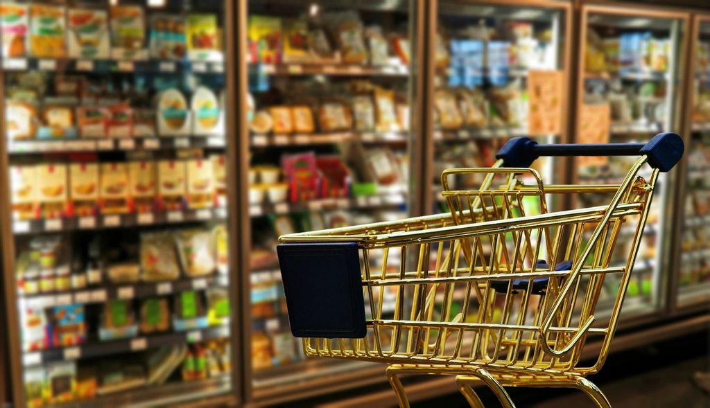 Shopping cart in a grocery store aisle, showing how to beat inflation as prices rise